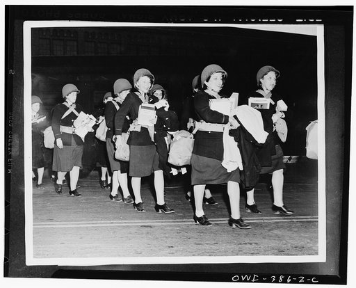 U.S. Army nurses marching to the troop ship carrying their few personal belongings and their equipment