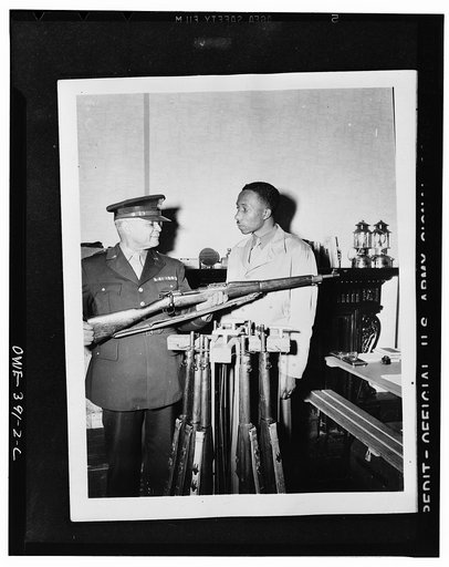 Brigadier General Benjamin O. Davis explaining the operation of a rifle to a U.S. Negro trooper somewhere in England