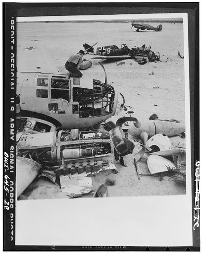 Ground crews of the Allied air forces dismantle a wrecked Heinkel III on a landing field between Daba and Fuka in Egypt