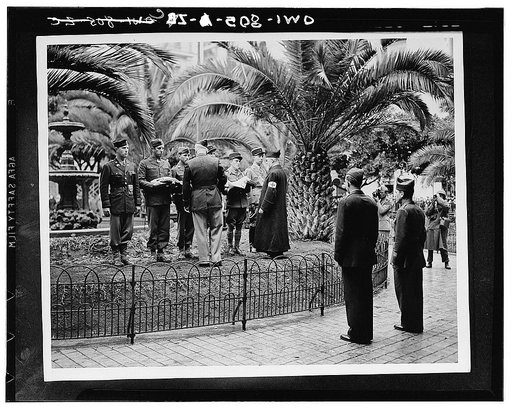American and French officers and United States enlisted men hold an Old Glory and the Tricolor just before a flag raising ceremony to commemorate the unity of the fighting allies in North Africa