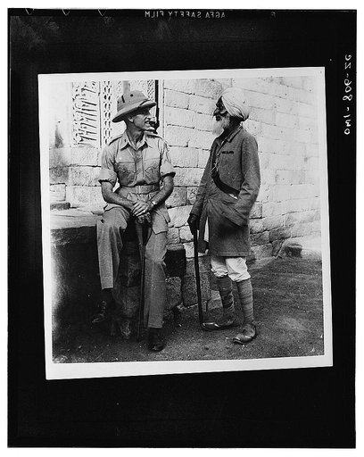 Captain James W. Snyder, Army intelligence officer, who was an historian in civilian life, with a veteranguide somewhere in India. The guide served in China during the Boxer rebellion. The ribbon he is wearing is for service with the late Lord Kitchner [i.e. Kitchener]. He also served under Lord Rob