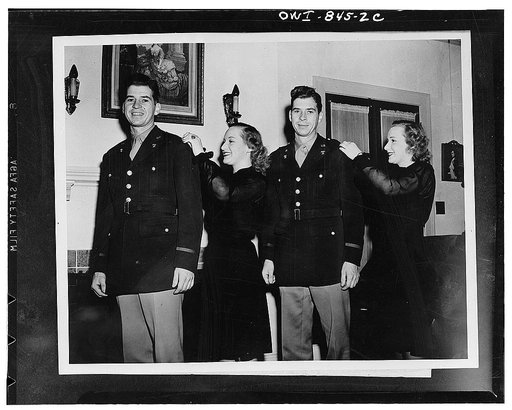 Fort Sam Houston, Texas. When the Kizer brothers of Belvidere, Illinois, were promoted to first lieutenants, the identical twin daughters of Colonel C. Lloyd Middleton, their commanding officer, pinned the silver bars on their shoulders. Left to right: Lieutenant Howard Kizer, Alice May Middleton, L