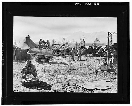 Men who are building the Alcan Highway, back in camp repairing tires and trucks