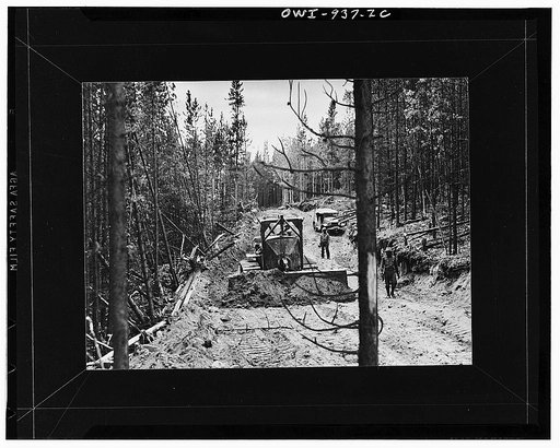 Caterpillar tractor pushing grader over a section of the Alcan Highway