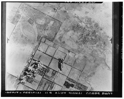 Tripoli, Libya. Allied air forces bombs rain down on Castel Benito airdrome during a daylight raid which damaged machine shops and other installations. In the foreground a train of bombs may be seen dropping from the bay of a United States plane