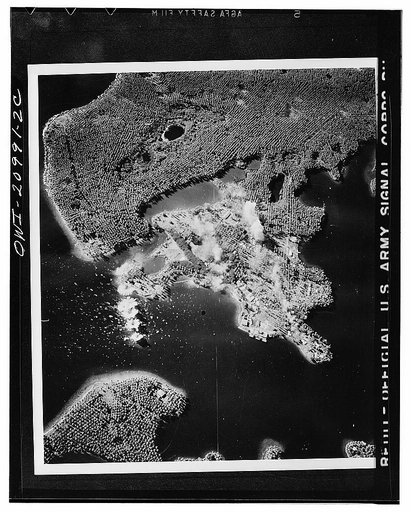 A train of six bombs from United States Army Air forces planes drops on the base of Mandang on the north coast of New Guinea held by the Japanese. During this raid more than thirty-eight tons of bombs were dropped on the airdrome and other vital objectives