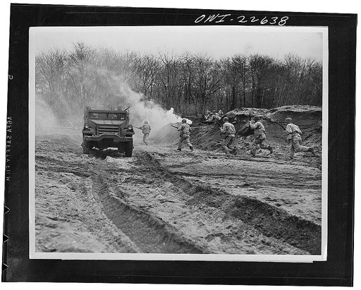 Mitchel Field, Long Island, New York. Camouflaged troops repel attack on half track carrying an x-ray portable field unit in a simulated battle test. The unit is set up in battlefront areas in a specially constructed dark-room tent