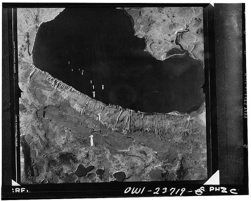 A train of bombs drops from United States Army Air Forces plane on territory in the Aleutians held by the Japanese. Our fighting forces harass the enemy at this important outpost daily