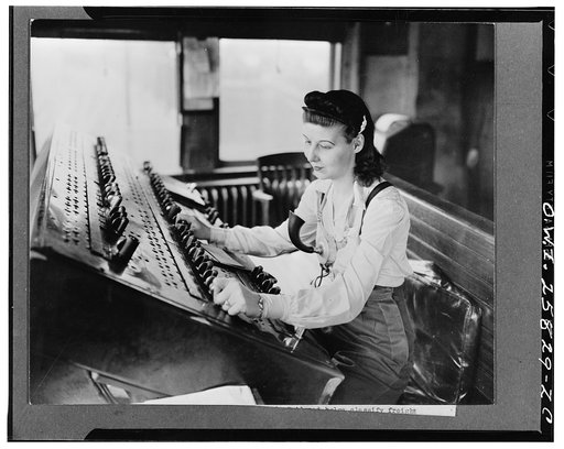 A switchtender on the Pennsylvania Railroad helping to classify freight trains at a large eastern freight yard. The electric controls on the board actuate rail switches in the yard. She is taking the place of a man now in the armed forces
