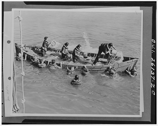 San Mateo, California. Bailing out a life boat at a United States Merchant Marine Cadet basic school