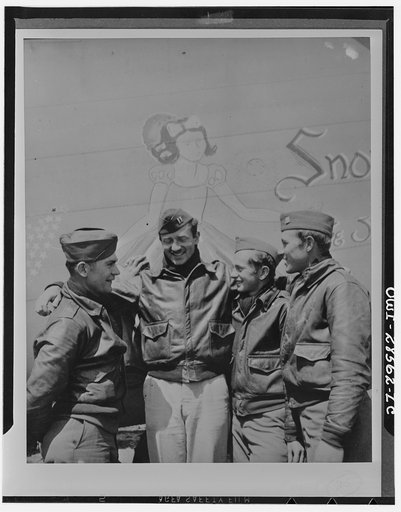 These four members of the crew of "Snow White" a B-24 bomber, of the United States Army Ninth Air Force, have completed 300 hours combat time in the same bomber they brought to the Mediterranean theater from America. Under the protecting wing of Snow White are (left to right) Technical Sergeant John