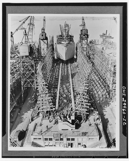 Bethlehem Fairfield shipyards, near Baltimore, Maryland. Construction of a Liberty ship. The ship sliding down the ways just twenty-four days after her keelplates were laid. It will take ten days longer to install furnishings. The ship weighs 3200 long tons and is known as a 10,500 ton cargo vessel