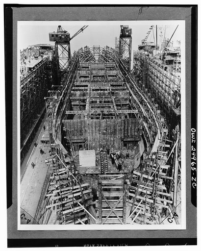 Bethlehem Fairfield shipyards, near Baltimore, Maryland. Construction of a Liberty ship. On the sixth day, 850 tons of the ship are in place. Bulkheads and girders below the second deck are in place. The bulkheads and inner bottom tanks were prefabricated