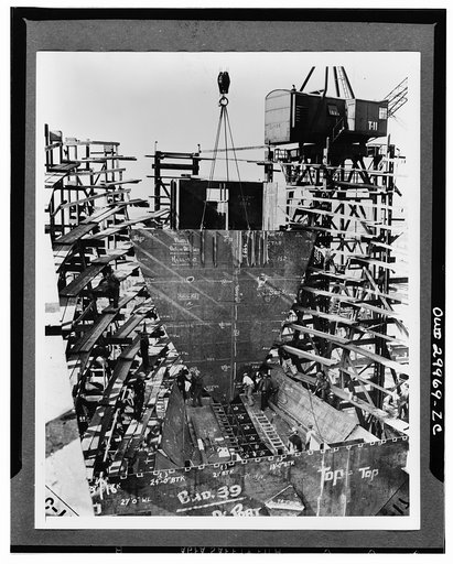 Bethlehem Fairfield shipyards, near Baltimore, Maryland. Construction of a Liberty ship. The sixteen-ton chain locker and collision bulkhead assembly being lowered into position in the forepeak of the ship