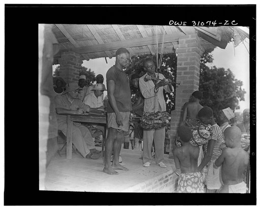 Moyen Congo bush, French Equatorial Africa. The trading activities of Africa. Rubber. Majordomo weighing the bundle brought in by the native boy in striped jersey at right