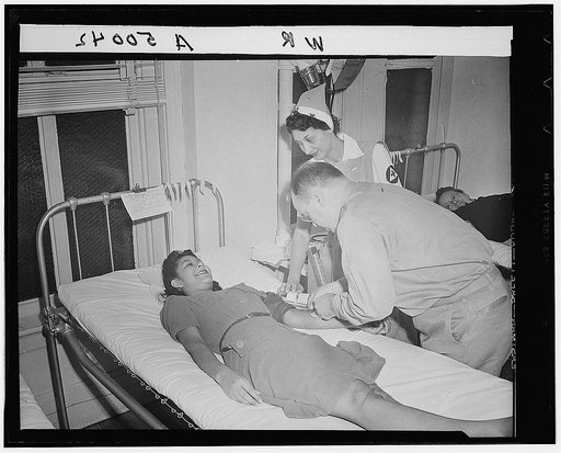 Volunteer blood donor giving her blood at a Red Cross donor center