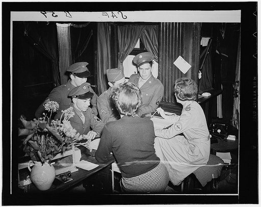 London, England. "Checking in" at the new Hans Cresent club for American servicemen. Left to right: Jerome Musco, of Providence, Rhode Island; Staff Sergeant Lloyd Tredway of Mines City, Montana; Corporal George Arvanities, of Lowell, Massachusetts; and Sergeant Oliver Gilbert of Labile, Missouri. A