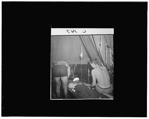 Buna, New Guinea. Lieutenant Frederick P. Ross, of Boston, administering a transfusion to a wounded man in a portable hospital just behind the front lines