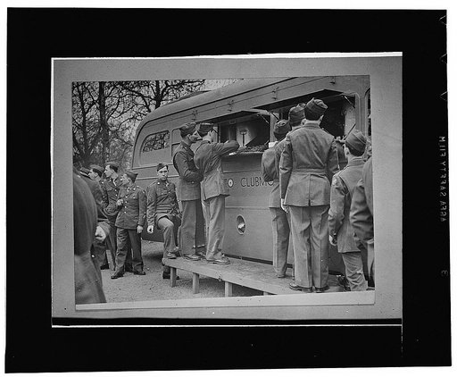 London, England. United States soldiers receiving refreshments, including doughnuts, from an American Red Cross clubmobile at the end of the Allied nations' parade in a "Wing for Victory" week celebration