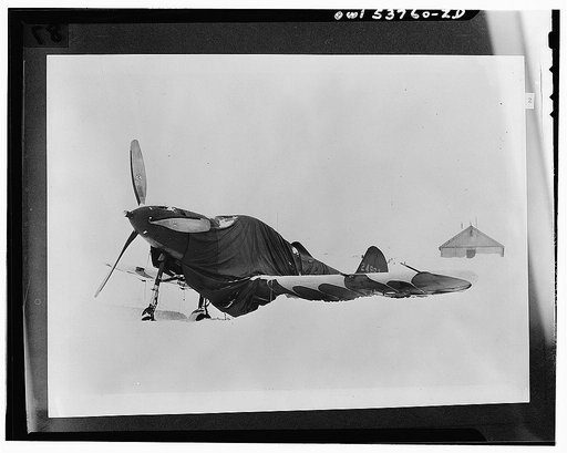 Nome, Alaska. A blanketed Airacobra plane in the snow at the Alaskan wing base of the Air Transport Command