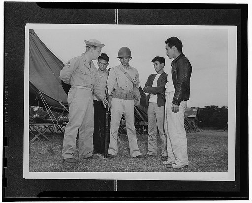 Kauai District, Territory of Hawaii. Sergeant John H. Chynoweth showing Mitsuru Doi, first AJA volunteer how to hold his rifle when at ease