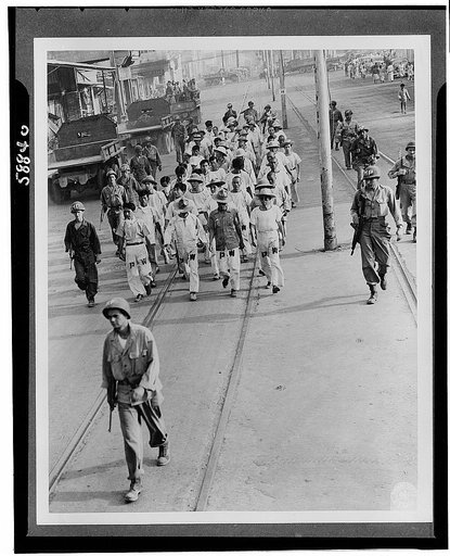 Japanese prisoners of war being guarded by Americans--probably in the Philippines