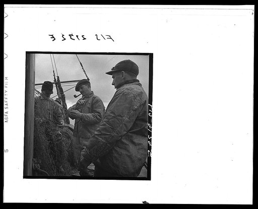 Provincetown, Massachusetts. The trawl is constantly under repair, and while one net is down a second is being mended by all hands aboard the Portuguese drag trawler, Francis and Marion