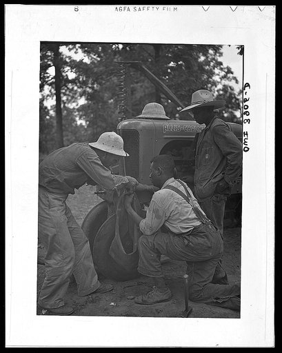 Lauderdale County, Alabama. Tennessee Valley Authority (TVA). Julien H. Case and his hired hand fix flat tractor tire