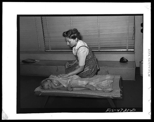 Queens, New York. Nursery school at the Queensbridge housing project. Waking a child after a nap