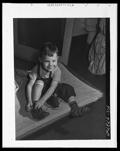 Queens, New York. Nursery school at the Queensbridge housing project. Child dressing after a nap