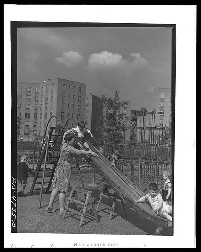 Queens, New York. Nursery worker with children in the playground at the nursery school at the Queensbridge housing project