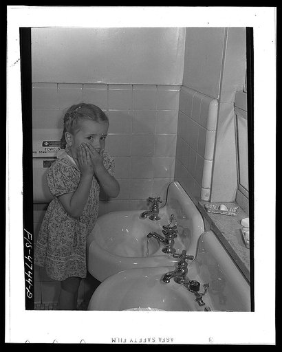 Queens, New York. Nursery school at the Queensbridge housing project. Child washing before lunch