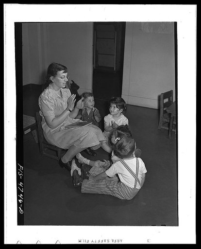 Queens, New York. Nursery school at the Queensbridge housing project. Nursery workers singing with the children
