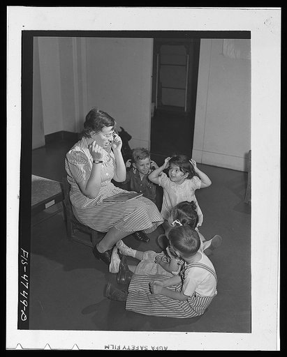 Queens, New York. Nursery school at the Queensbridge housing project. Nursery workers singing with the children