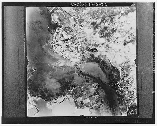 Cagliari, Sardinia. 1942(?) Two strings of bombs are seen striking the seaplanes and airdrome