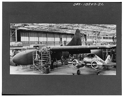 Untitled negative showing a C-76 Caravan airplane (larger aircraft) with an AT-9A airplane, probably at the Curtiss-Wright plant