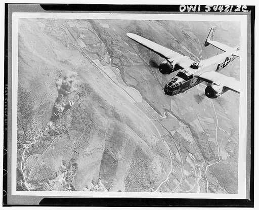 A Nazi supply dump goes up in smoke. A U.S. B-25 medium bomber roars over Tivoli, Nazi supply center ten miles east of Rome. Now a smoking ruin, it was used by the Germans as a terminal for routing reinforcements to battle areas