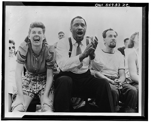 Paul Robeson and Jose Ferrer watching a softball game with other members of Othello production, Central Park, New York City