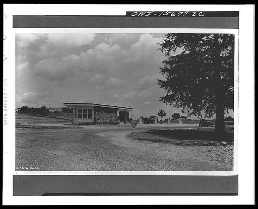 Filling and service stations are provided as necessary parts of employee villages. The one shown on this photograph pioneered in the United States the center location with respect to the two directions of highway traffic which eliminates the need for cars turning out of line to reach the pumps, this