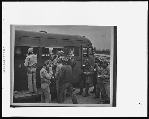 London, England(?). Three girls in the Red Cross clubmobile pass out some 1600 doughnuts each day, along with 500 cups of coffee, smokes, candy, games, gooks and hometown papers. Music from home comes from a record player in the clubmobile