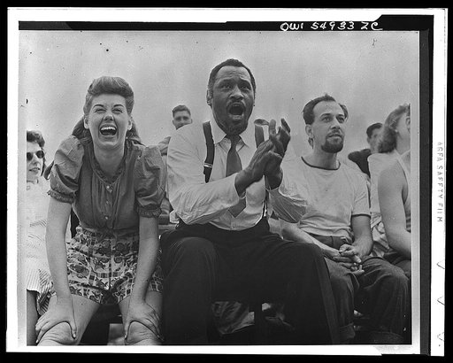 Paul Robeson and Jose Ferrer watching softball with other members of Othello production, Central Park, New York City
