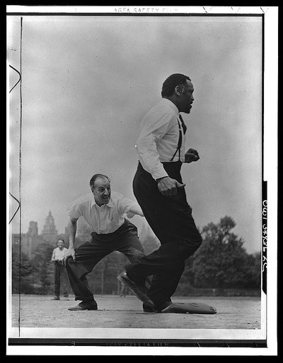 Louis Calhern and Paul Robeson playing softball with other members of Othello production, Central Park, New York City