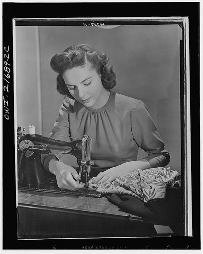 Cynthia stiches basic seams before fitting, a principle of simplified sewing. While no new sewing machines are being made and the factories are turning out war goods (WPB (War Production Board) assures an adequate supply of machine repair parts for home dressmakers. To fully utilize existing machine