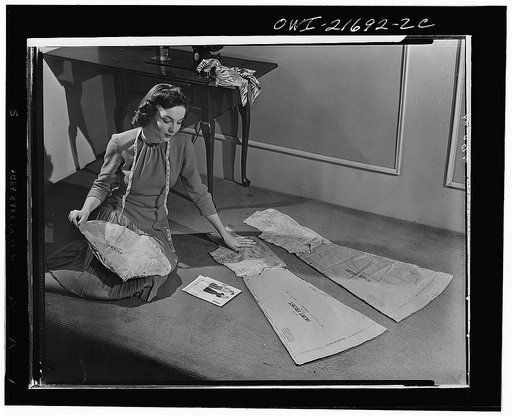 Simplified sewing methods now being taught to thousands of American women through stores, pattern companies, and radio show how to assemble a pattern as Cynthia is doing. As they did in the last war, thousands of women are asking for sewing instructions. Streamlined methods make sewing quick and eas