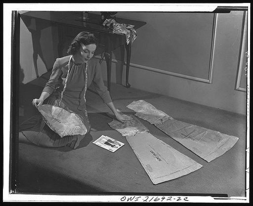 Simplified sewing methods now being taught to thousands of American women through stores, pattern companies, and radio show how to assemble a pattern as Cynthia is doing. As they did in the last war, thousands of women are asking for sewing instructions. Streamlined methods make sewing quick and eas