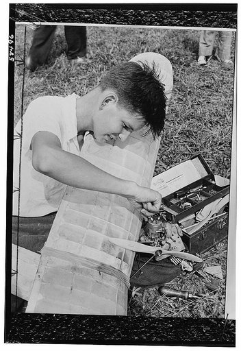 America's youth builds and flies model planes on miniature flying fields. This young mechanic, equipped with a well-fitted tool kit, goes after engine trouble in his model plane. Like millions of other boys, he is vitally interested in aero-modelling, and is learning in his home workshop principles 
