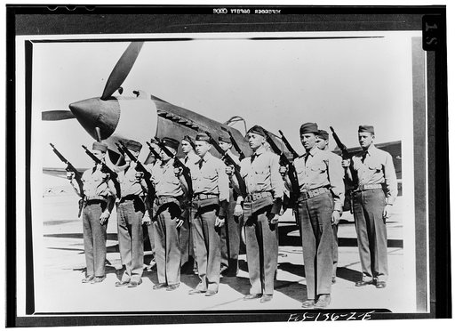 Hamilton Field, California. A security squad lined up in front of a fast pursuit ship and fully equipped with Thompson sub-machine guns that will pour out 500 large-caliber slugs a minute