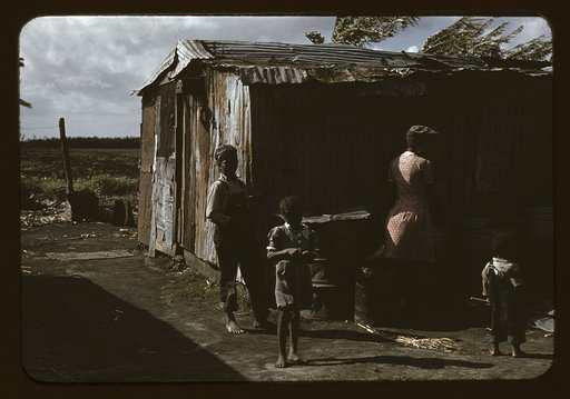 Negro migratory workers by a shack, Belle Glade, Fla.