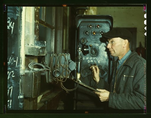 Hump master in a Chicago and Northwestern [i.e. North Western] railroad yard operating a signal switch system which extends the length of the hump track. He is thus able to control movements of locomotives pushing the train over the hump from his post at the hump office; Chicago, Ill.