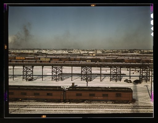 Looking toward the Chicago and Northwestern [i.e. North Western] railroad classification yard. The trestle runs from the ice house to the yard. The old cars in the foreground are used as living quarters for some yard workers and itinerant help. Town of Melrose Park is in background